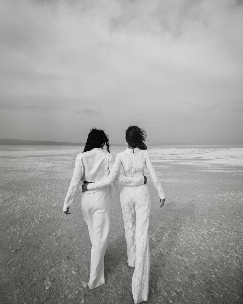 Team Fifteen Twelve two women walking together on the beach