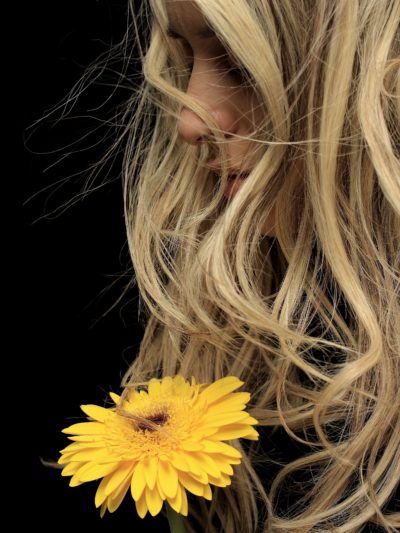 Beautiful woman with blonde hair holding a flower